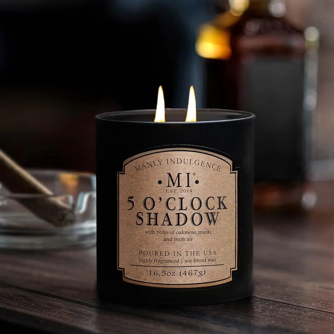 Candle labeled '5 O'Clock Shadow' on a wooden surface with a blurred background