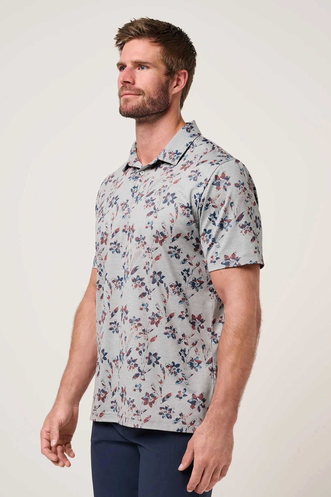 Man wearing a floral short-sleeve shirt against a plain background