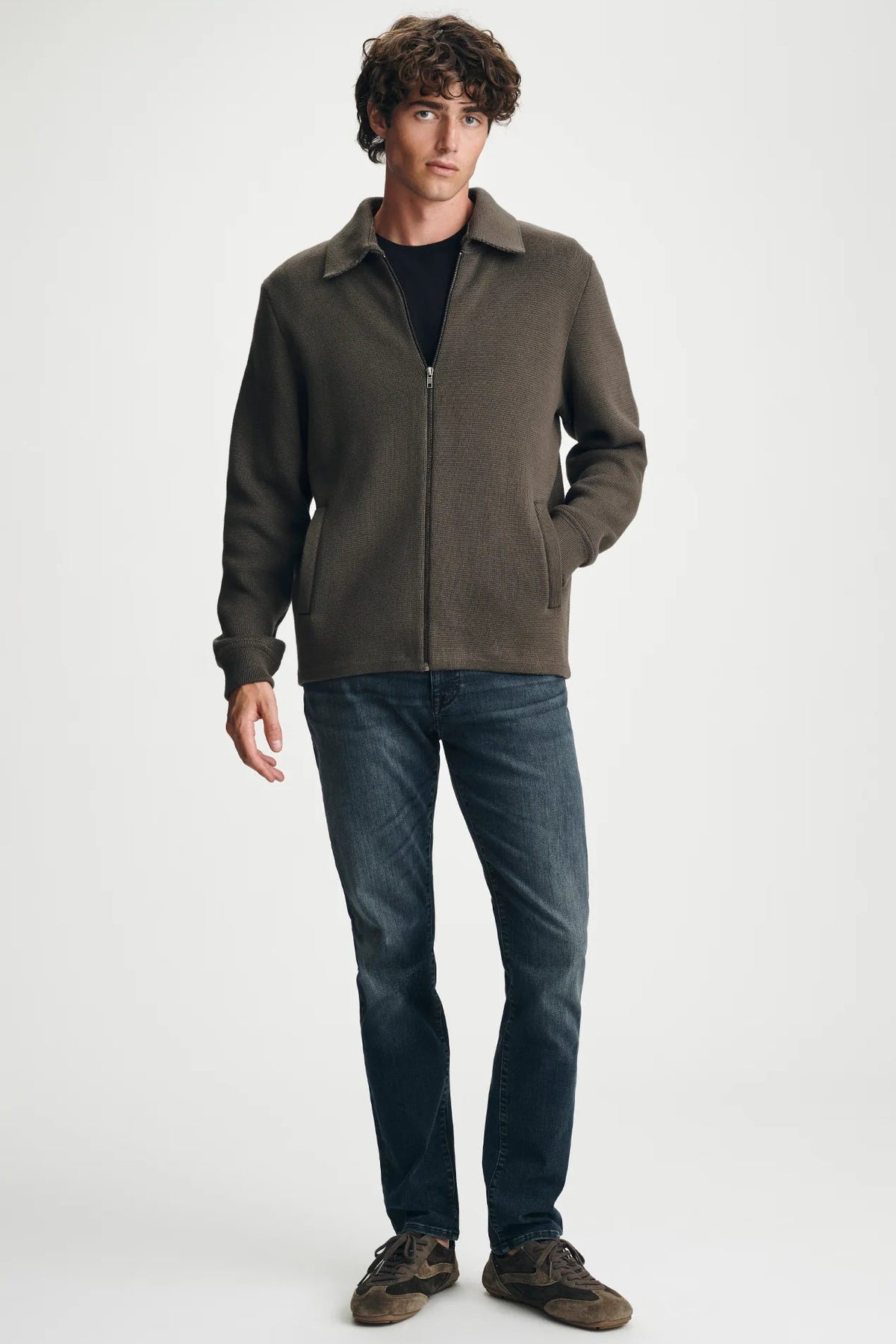 man in brown sweater and jeans