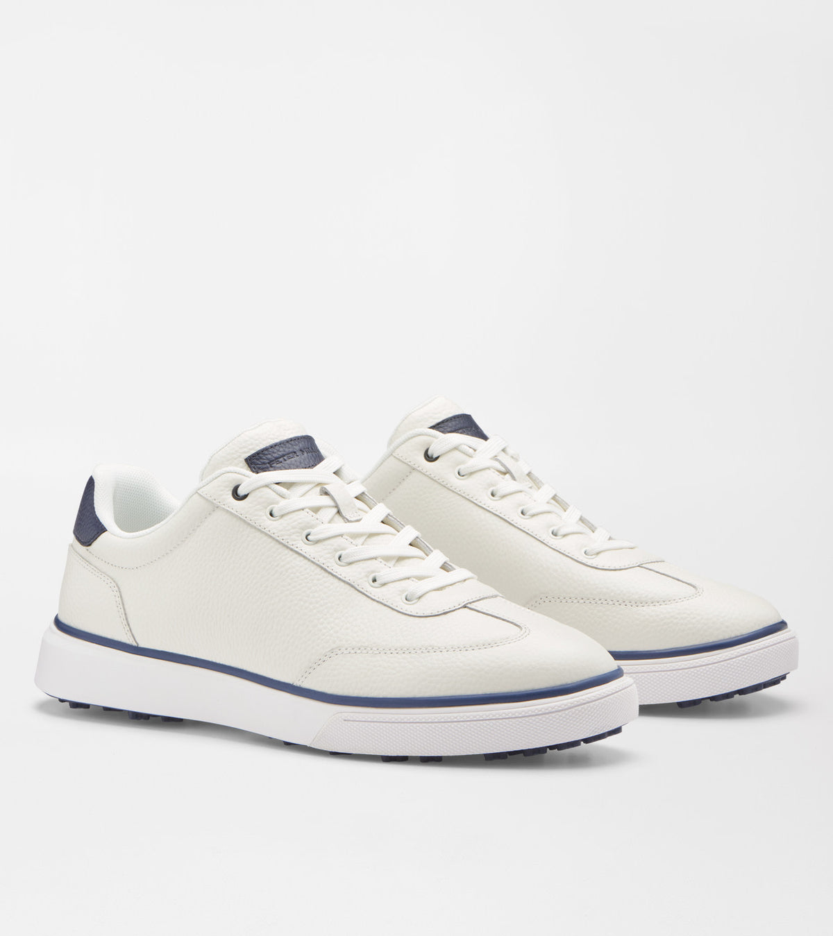 A pair of white leather low-top sneakers with navy blue accents on the heel tab, laces, and midsole stripe, shown on a light gray studio background.