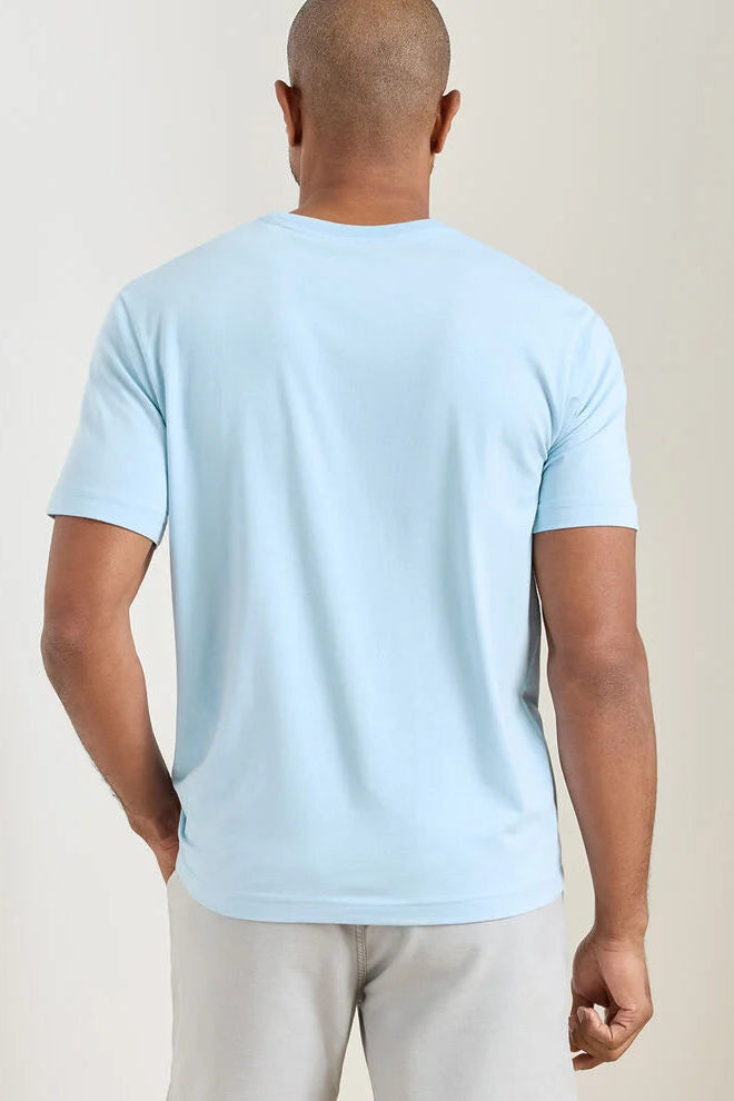 Man wearing a light blue t-shirt against a beige background
