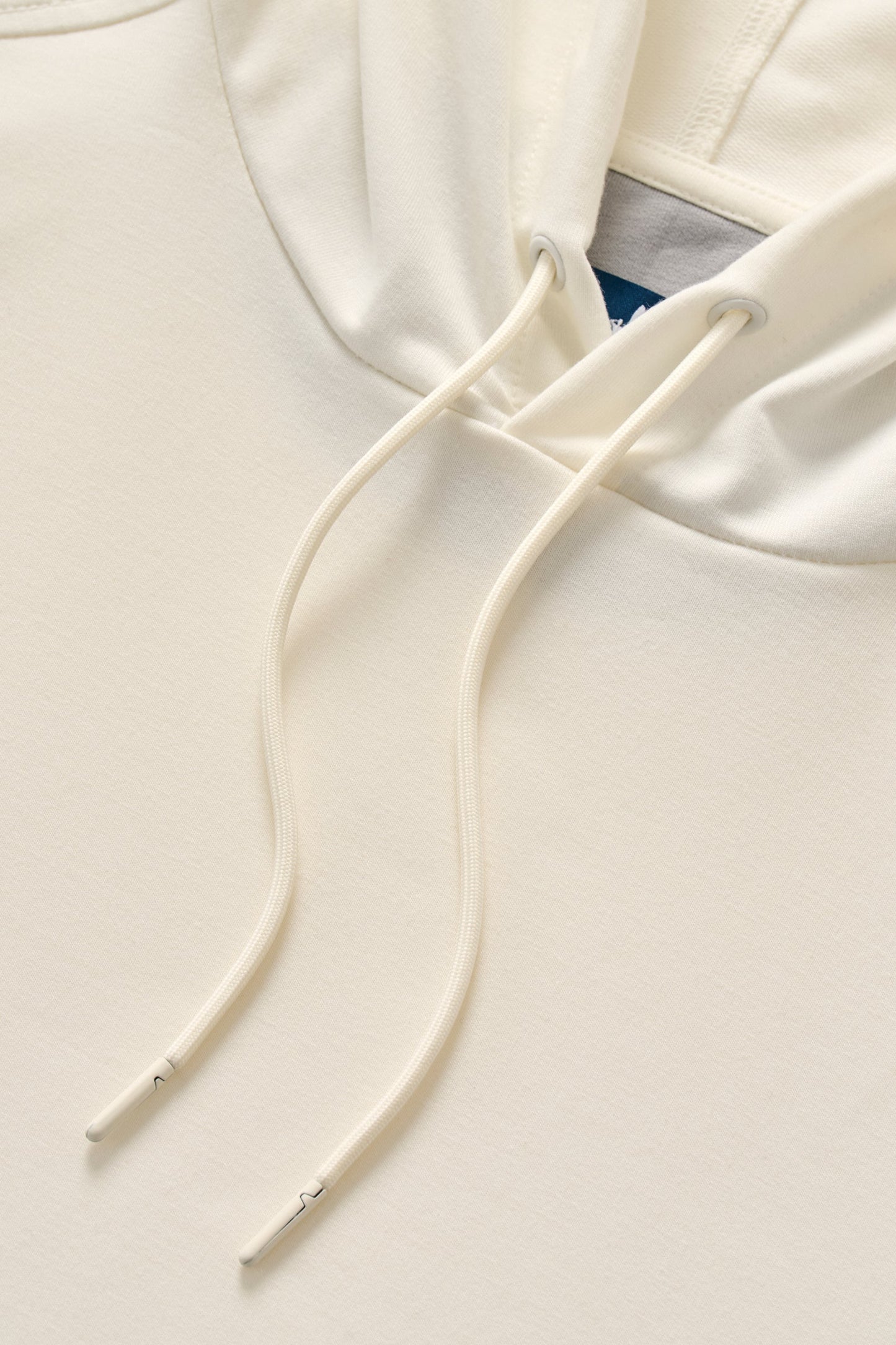 Close-up of a white hoodie with drawstrings on a light gray background