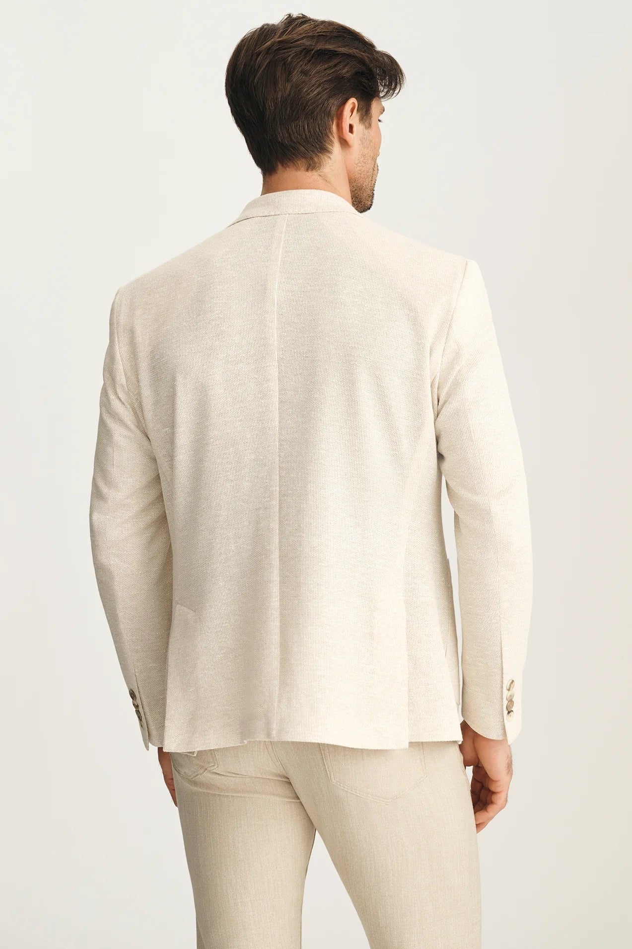 Man wearing a beige suit on a white background