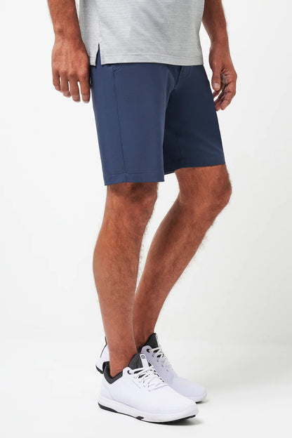 Person wearing navy shorts and white sneakers on a white background