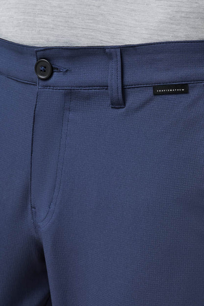 Close-up of blue pants with a brand label on a gray background