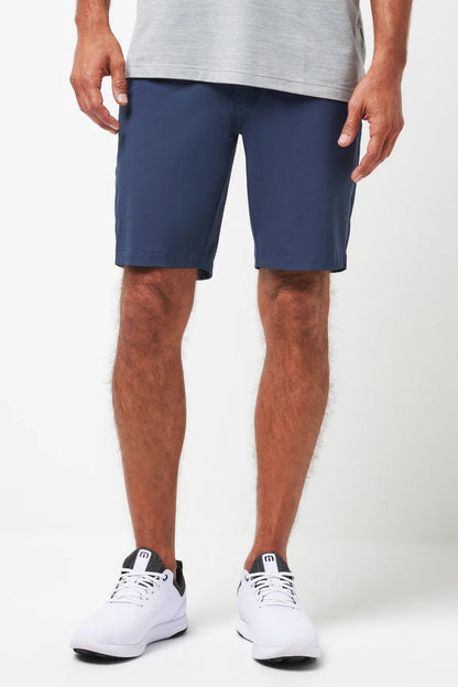 Person wearing navy shorts and white sneakers on a white background