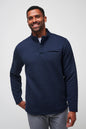 Man wearing a navy quilted pullover against a light gray background