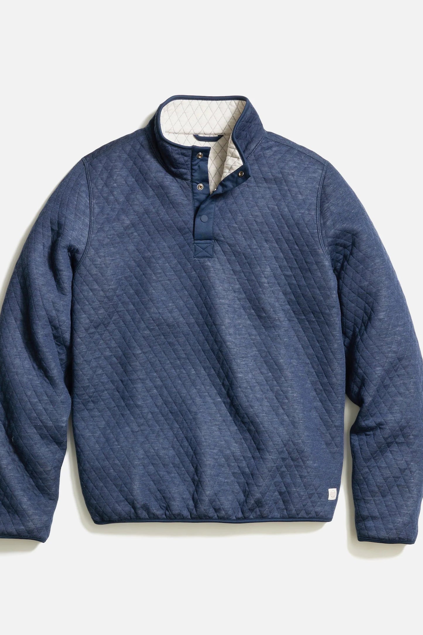 A navy blue quilted pullover jacket with a half-button placket and a light beige lining visible at the collar, shown flat on a light gray background.