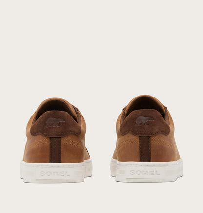 Brown suede shoes with white soles on a beige background