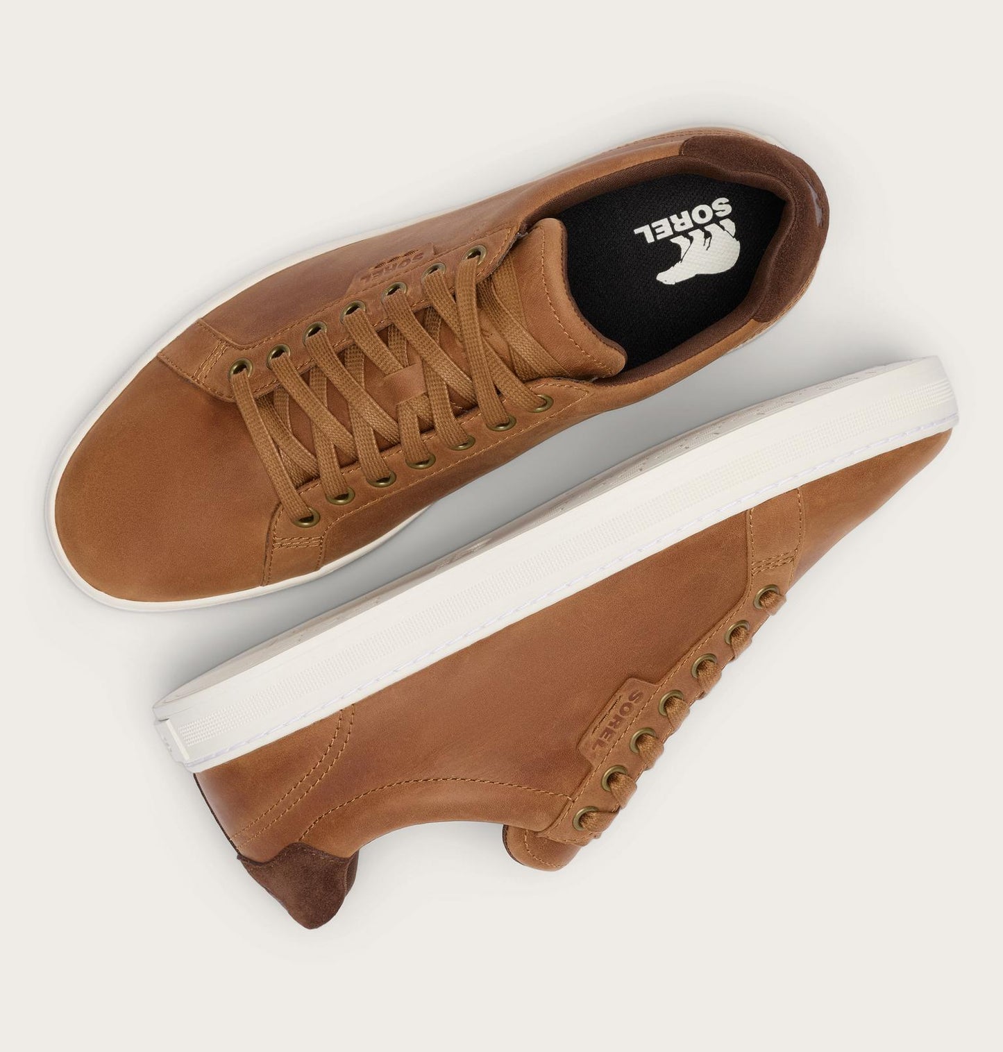 Brown leather sneakers with white soles on a light gray background