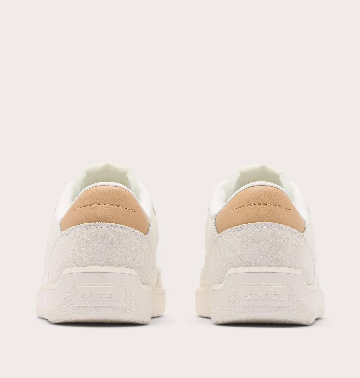 White sneakers with tan accents on a white background