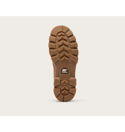 A single brown rubber shoe sole shown upright against a light beige background, featuring deep tread patterns and a small visible Stance logo near the heel.
