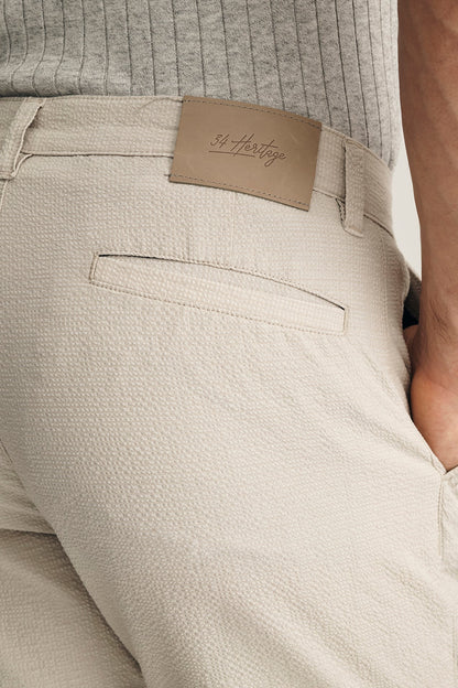 Beige pants with a brand label on a neutral background