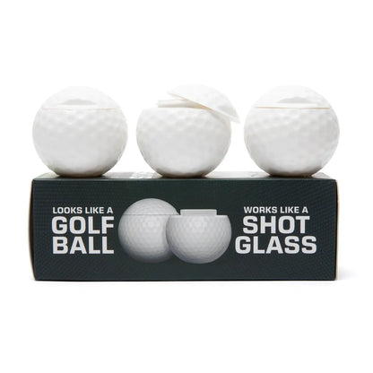 Three golf ball-shaped shot glasses on a black box with text.