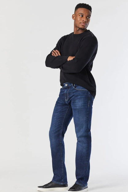 Man wearing a black sweater and blue jeans on a white background