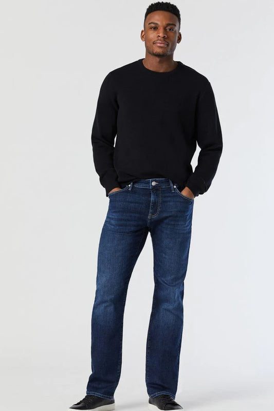 Man wearing a black sweater and blue jeans on a white background