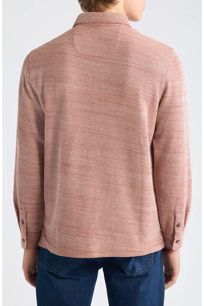A person shown from the back wearing a textured, long-sleeve button-up shirt in a dusty rose pink color, paired with blue jeans against a light gray studio background.