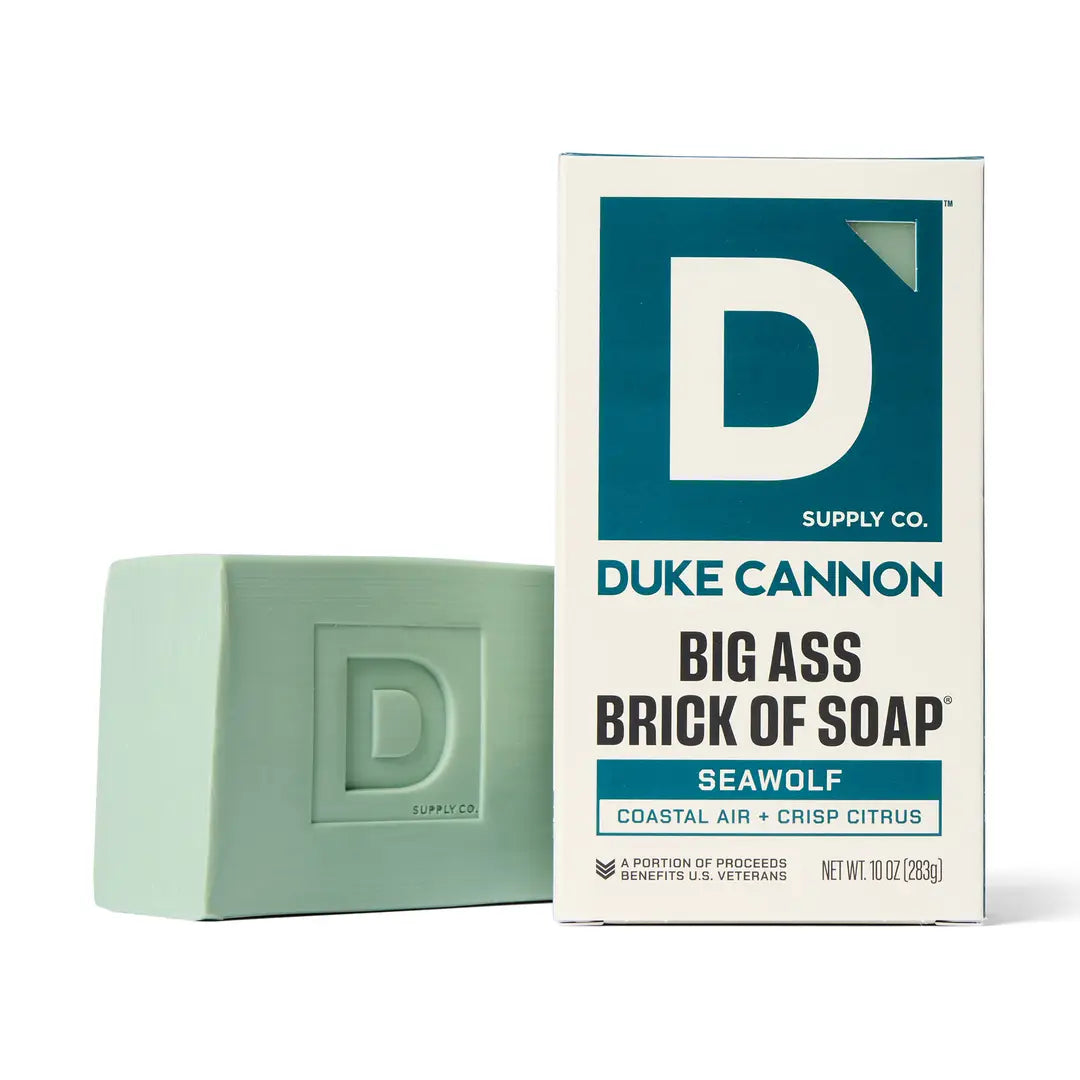 Green bar of soap next to its packaging with 'Duke Cannon' branding on a white background
