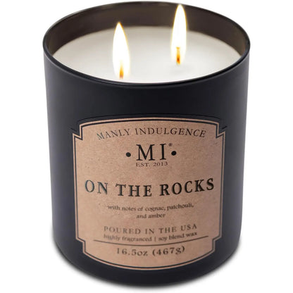 Candle in a black container with 'Manly Indulgence' label on a white background