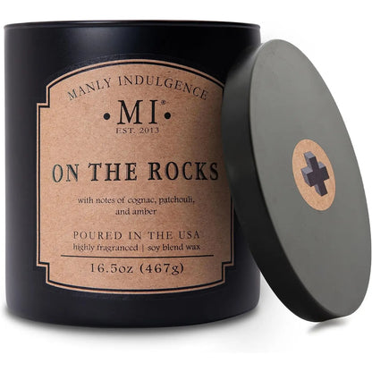 Candle in a black tin with 'Manly Indulgence' label on a white background