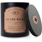 Candle in a black tin with 'Manly Indulgence' label on a white background