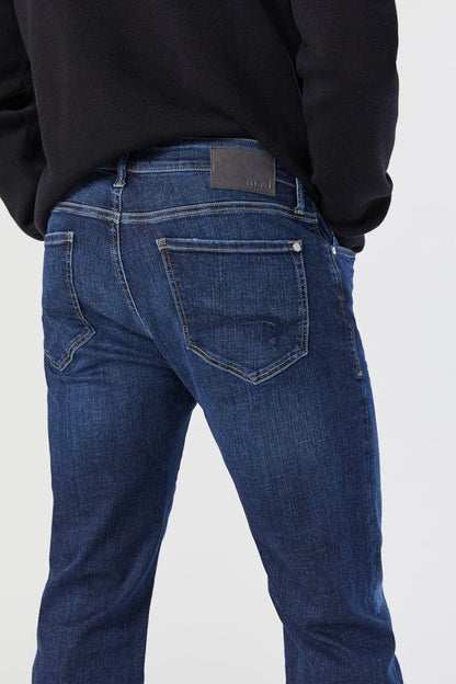 Person wearing blue jeans with a white background