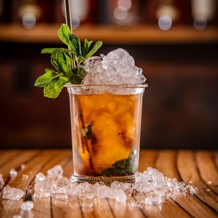 Cocktail with ice and mint leaves on a wooden surface