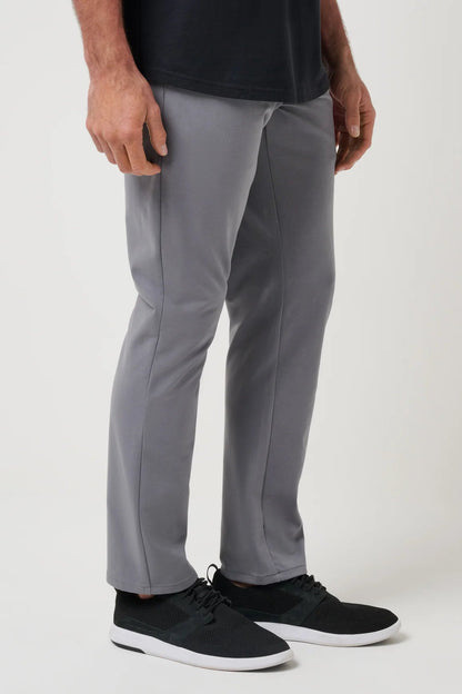 Person wearing gray pants and black shoes on a white background