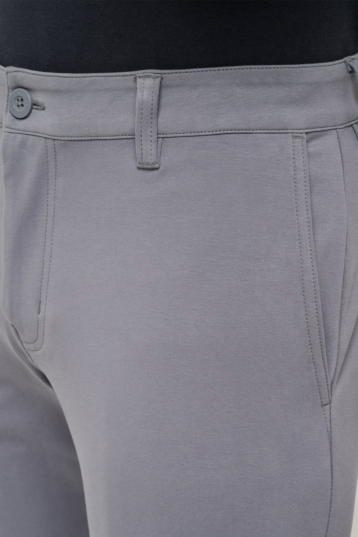 Gray pants with a button detail on a neutral background