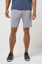 Person wearing light gray shorts and dark shoes on a white background
