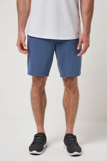Person wearing blue shorts and black shoes on a white background