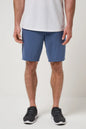Person wearing blue shorts and black shoes on a white background