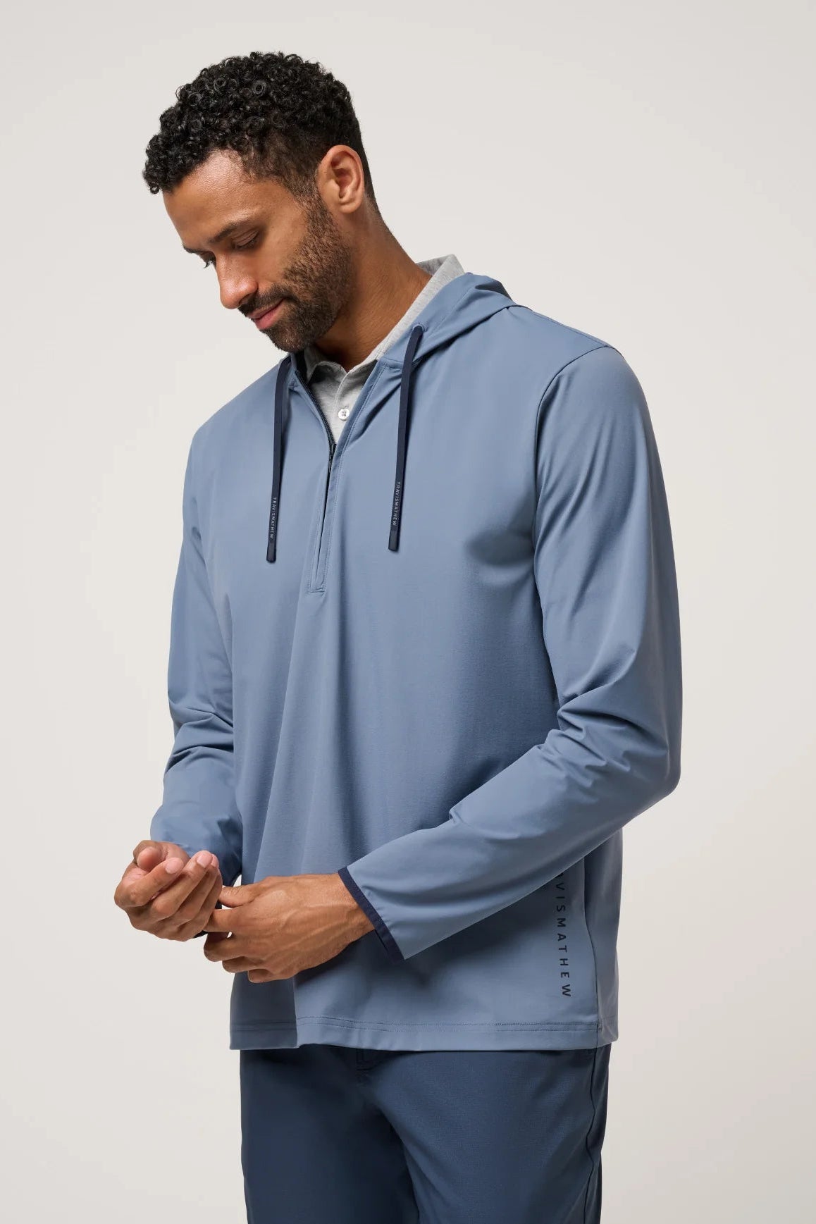 Man wearing a blue hoodie and pants on a plain background