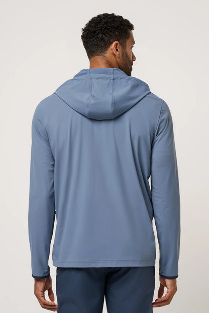 Man wearing a blue hoodie from behind on a light gray background
