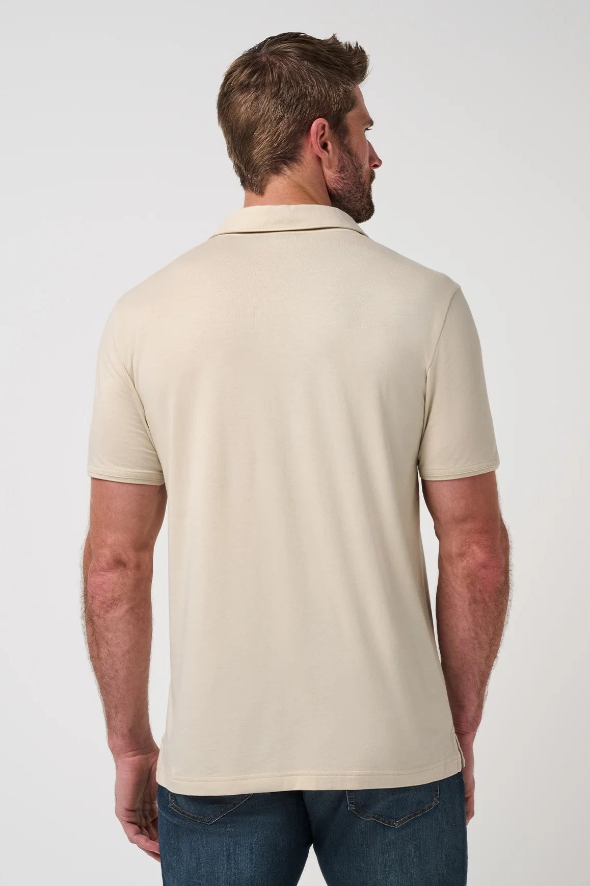Man wearing a beige polo shirt on a white background