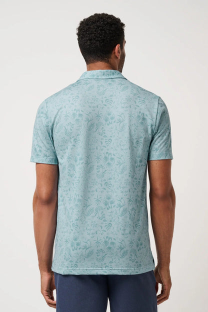 Man wearing a light blue patterned polo shirt on a white background