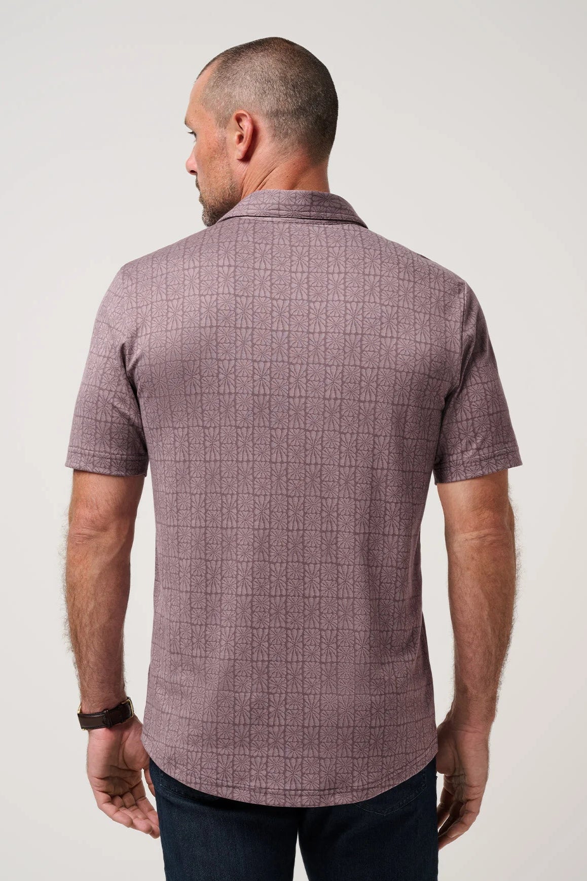 Man wearing a short-sleeve checkered shirt against a plain background