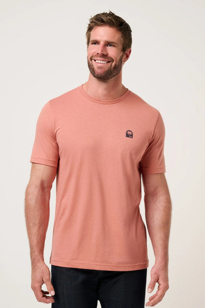 Man wearing a pink t-shirt with a logo on a white background