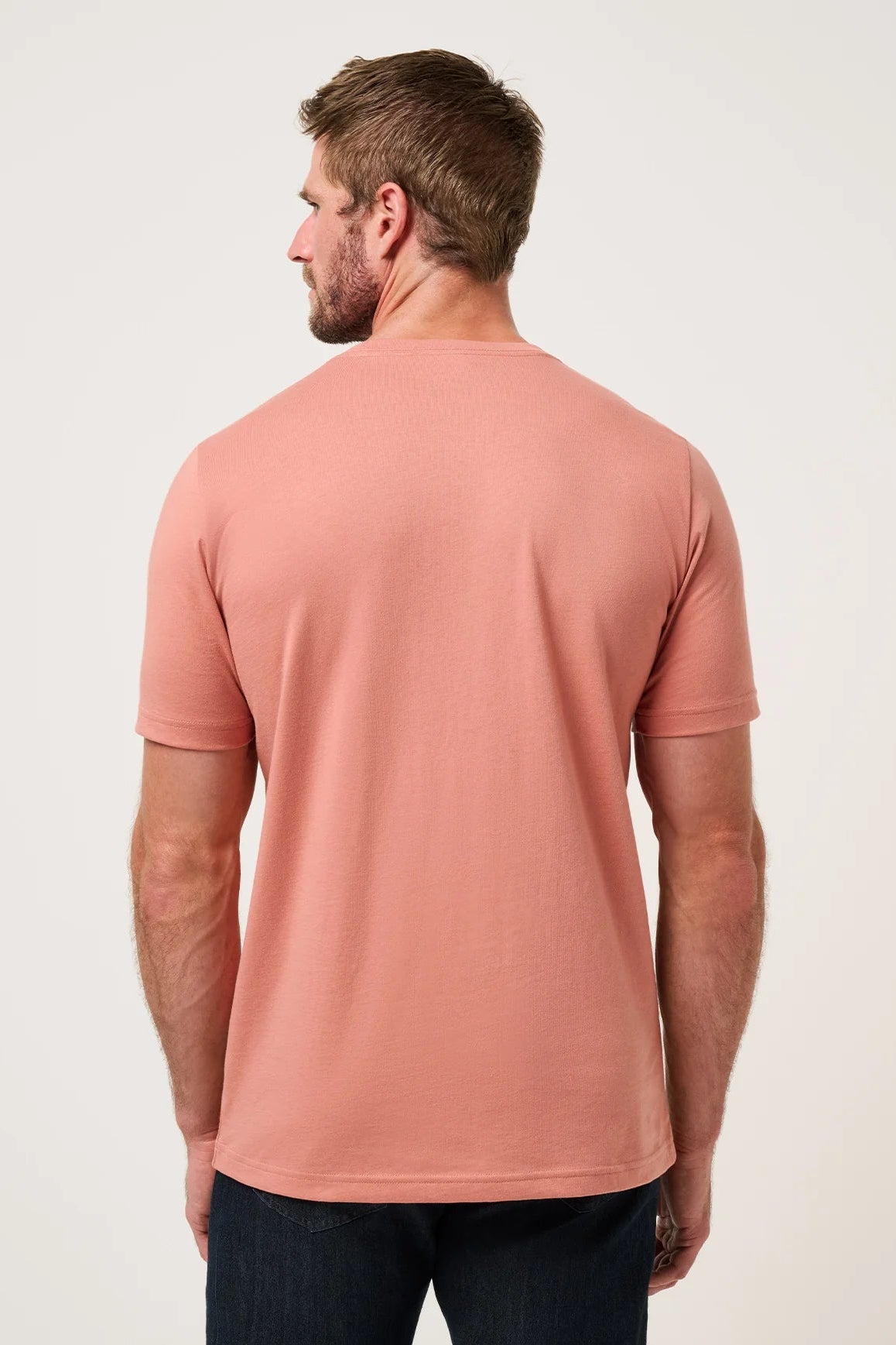 Man wearing a pink t-shirt against a white background