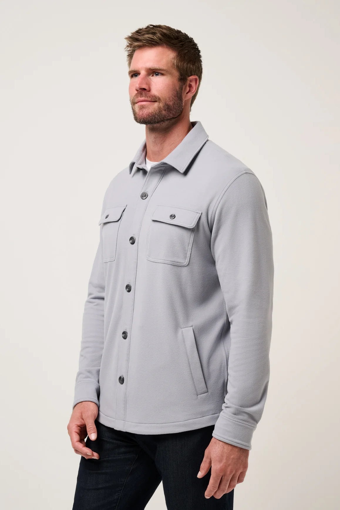 Man wearing a light gray jacket on a plain background