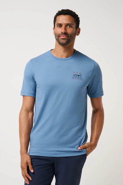 Man wearing a blue t-shirt with a logo on a light gray background