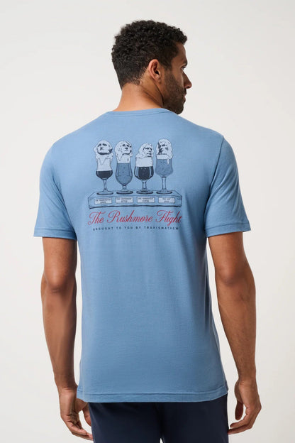 Man wearing a blue t-shirt with a graphic design on the back against a white background