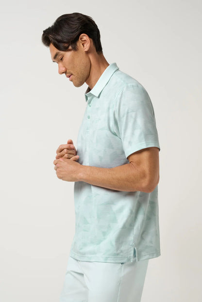 Man wearing a light blue polo shirt against a plain background