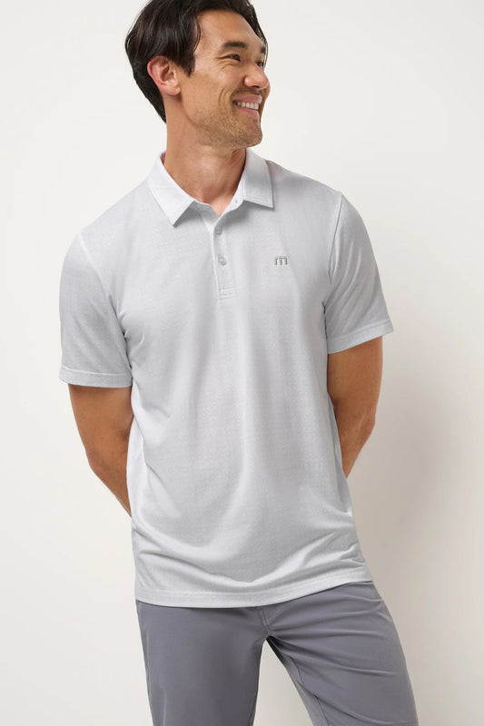 Man wearing a light gray polo shirt with a small logo on a plain background