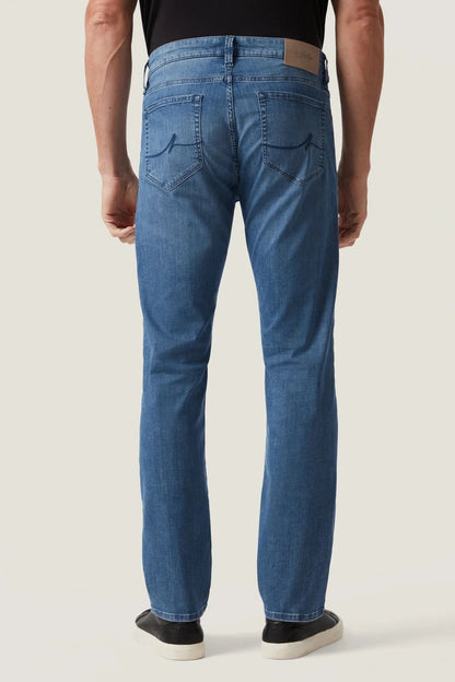 Person wearing blue jeans on a plain background