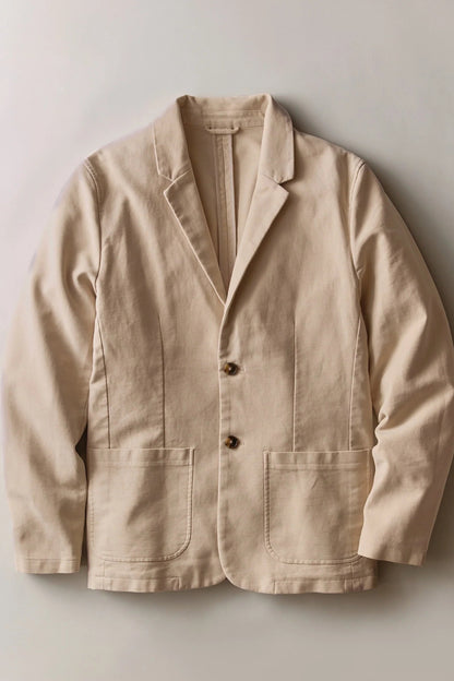 A light beige linen-blend blazer jacket with notch lapels, a two-button front closure, and two large front patch pockets, laid flat against a neutral light gray background.