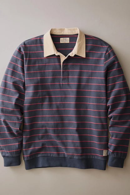 A long-sleeve rugby-style polo shirt with horizontal navy and red stripes, featuring a contrasting beige collar and a partial button placket, displayed flat against a neutral gray background.