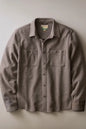 A long-sleeve button-up shirt jacket in a heathered taupe-brown fabric, featuring two buttoned chest pockets and a classic collar, laid flat against a neutral light gray background.