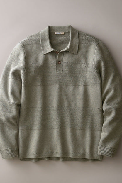 A long-sleeve knit polo shirt in a muted sage green color, featuring subtle horizontal textured stripes and a two-button placket, laid flat against a neutral gray background.