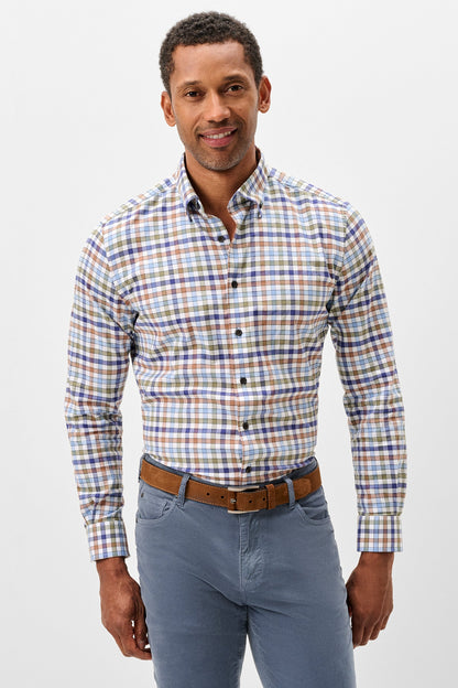 A man wearing a long-sleeve button-down shirt with a multicolor plaid pattern in blue, orange, and white, paired with blue jeans and a brown belt, against a light gray studio background.